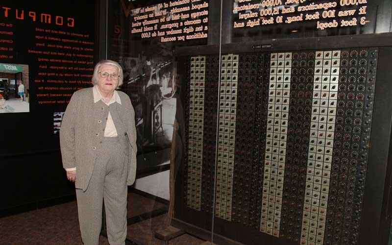 吉恩在陆军博物馆|吉恩站在美国陆军博物馆的ENIAC展台前.S. 位于马里兰州阿伯丁试验场的陆军军械博物馆.  (美国陆军研究实验室阿伯丁试验场Robert Sheroke提供.)