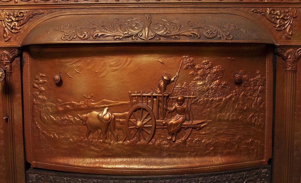 A photo of an elaborate cast copper pictorial firebox closure inside the 憔悴的房子.